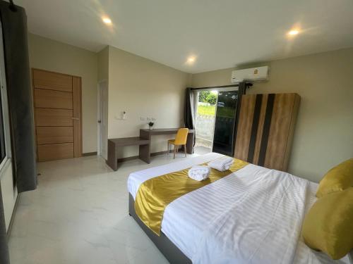 1 dormitorio con cama, escritorio y mesa en Marigold Aonang Resort, en Ao Nang Beach