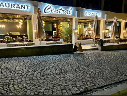 a cobblestone street in front of a restaurant at night at Pensiunea Boutique Central in Băile Herculane