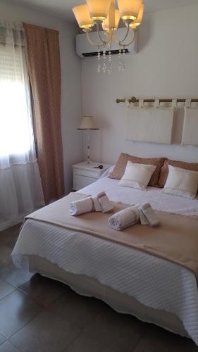 a bedroom with a large white bed with two pillows at MM Apart in Río Cuarto