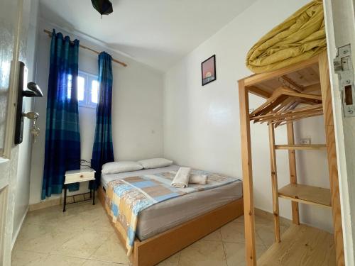a bedroom with a bed and a bunk bed at Cozy Surf House in Taghazout