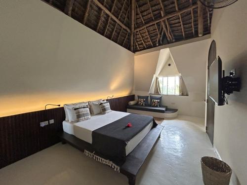 ein Schlafzimmer mit einem großen Bett und einem Fenster in der Unterkunft Kuwa Zanzibar in Kiwengwa