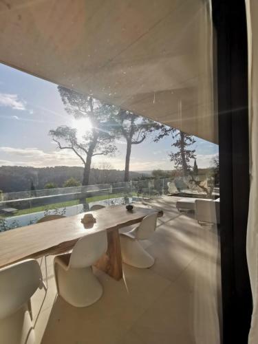 une table et des chaises en bois sur un balcon dans l'établissement Maison d'Architecte piscine vue exceptionnelle uzès à pied, à Uzès