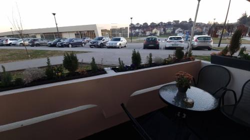 a patio with a table and cars parked in a parking lot at Studio APARTMAN 404-401 in Vukovar