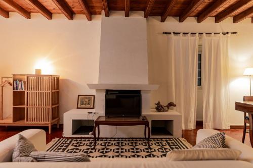 a living room with a couch and a fireplace at Traumgarten - Rustic House - Sunset & SeaView in Várzea