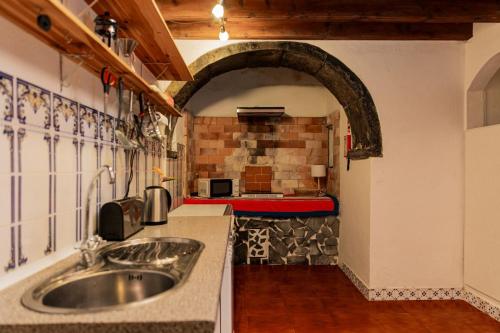 uma cozinha com um lavatório no meio de um quarto em WelcomeBuddy - Traumgarten Rustic House (Sunset) na Várzea