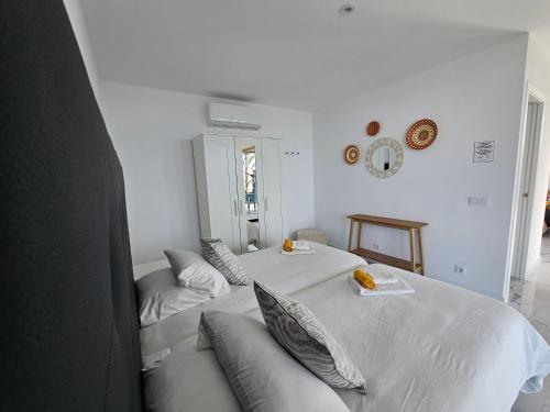 ein weißes Schlafzimmer mit 2 Betten und Kissen in der Unterkunft Las Norias Apartamentos & Grill in Tazacorte