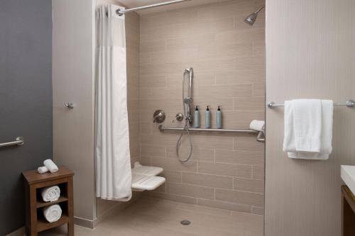 a bathroom with a shower with a toilet at Courtyard by Marriott Lubbock Downtown/University Area in Lubbock