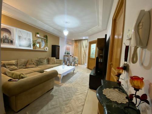 ein Wohnzimmer mit einem Sofa und einem Tisch in der Unterkunft Magnifique Appartement S1 a sousse in Sousse