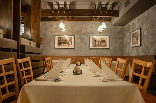 a dining room with a long table with laptops on it at Hotel Esprit in Špindlerův Mlýn