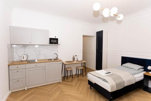 1 dormitorio blanco con 1 cama y cocina en Apartamenty ZZ Stargard, en Stargard