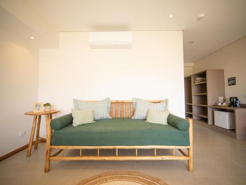 a living room with a green couch in a room at Hotel Velas do Engenho in Ilhabela