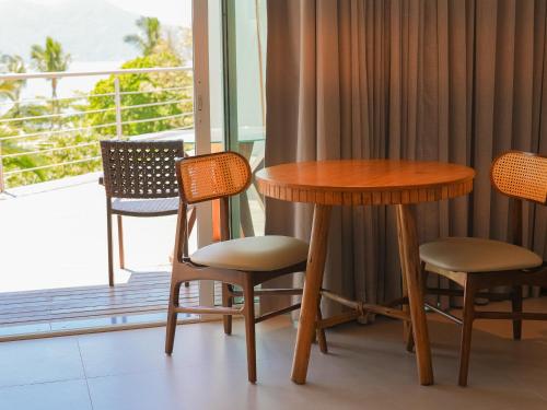 a table and chairs in a room with a balcony at Hotel Velas do Engenho in Ilhabela
