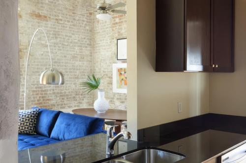 a kitchen with a blue couch and a table at Constance Lofts by Black Swan in New Orleans