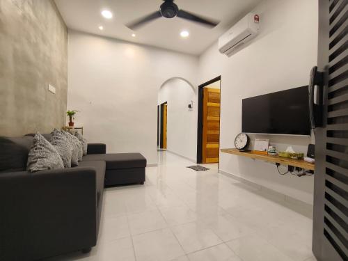 a living room with a couch and a flat screen tv at Roomstay Bilik shj Alor Setar Derga Jaya 10mins to Aman Central in Alor Setar