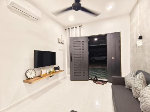 a living room with a couch and a flat screen tv at Roomstay Bilik shj Alor Setar Derga Jaya 10mins to Aman Central in Alor Setar