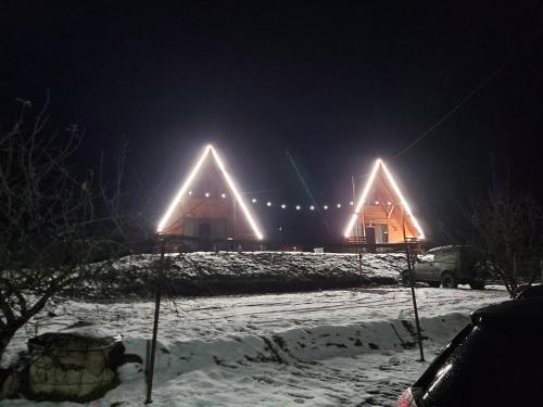 uma casa com luzes na neve em Cazare La Nea Marin A Frame em Ciobotani