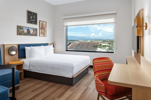 a hotel room with a bed and a window at Hampton By Hilton Guanacaste Airport in Liberia