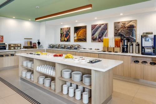a kitchen with a counter with plates and cups at Hampton By Hilton Guanacaste Airport in Liberia