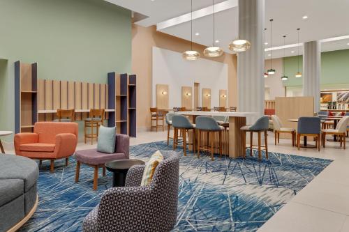 a waiting room with colorful chairs and tables at Hampton By Hilton Guanacaste Airport in Liberia