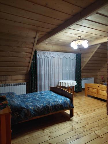 a bedroom with a bed and a chair in a room at Pokoje u Bogusi in Chochołów