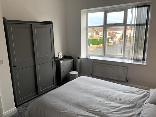 a bedroom with a white bed and a window at New large 2 bedroom apartment with private parking 