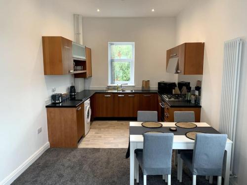 a kitchen with a table and chairs in a kitchen at New large 2 bedroom apartment with private parking in Lea Town