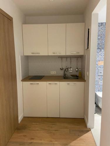 a small kitchen with white cabinets and a sink at Maritime Suites in Hersonissos
