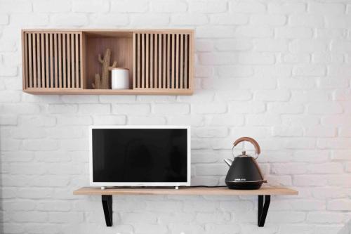 - une télévision assise sur une table avec une bouilloire dans l'établissement La Petite Mer-Veille avec vue mer et parking privé, à Canet