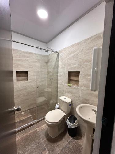 a bathroom with a toilet and a shower and a sink at JAMJALI HOTEL ARMERO GUAYABAL (PISCINA-COCINA LIBRE) in Guayabal