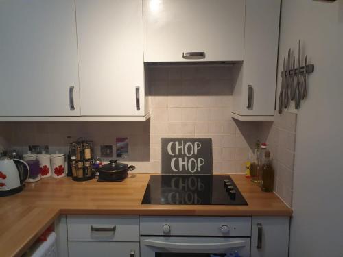 a kitchen with white cabinets and a stove top oven at The Hidden Gem in Watford