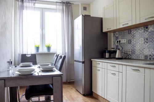 una cocina con armarios blancos y una mesa con platos. en AS apartmán sever en Košice