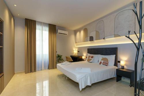 1 dormitorio con 1 cama blanca grande y escritorio en Appartamento Domus Lavica en Catania