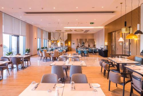 - un restaurant avec des tables et des chaises dans une salle dans l'établissement Hilton Garden Inn Samarkand Sogd, à Samarcande