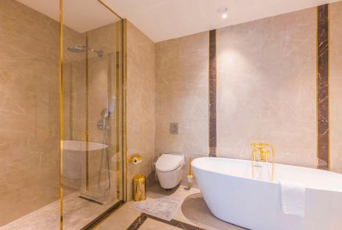 a bathroom with a tub and a shower and a toilet at Hilton Garden Inn Samarkand Sogd in Samarkand