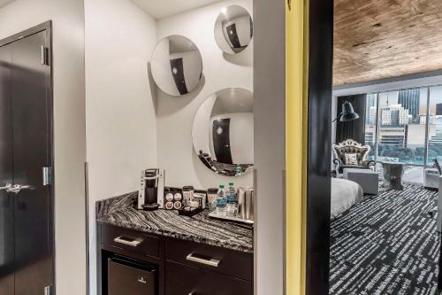 a bathroom with a vanity and mirrors in a hotel room at Lorenzo Hotel Dallas, Tapestry Collection by Hilton in Dallas