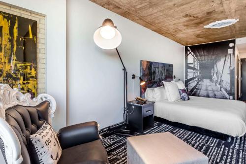 a hotel room with a bed and a chair at Lorenzo Hotel Dallas, Tapestry Collection by Hilton in Dallas