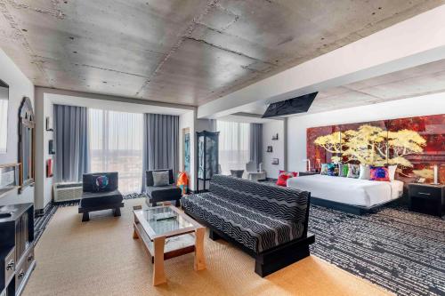 - un salon avec un canapé et un lit dans l'établissement Lorenzo Hotel Dallas, Tapestry Collection by Hilton, à Dallas