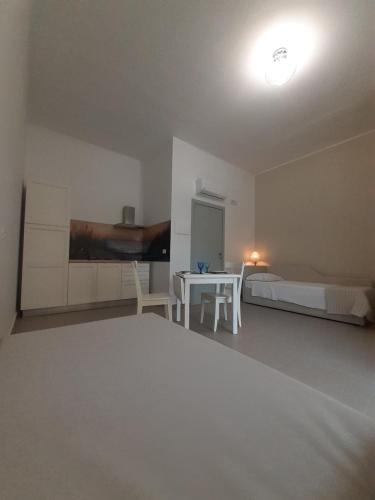 a bedroom with a bed and a table and a bed and a table and chairs at Vento di Mare in Piraino