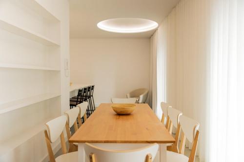 a dining room with a wooden table and chairs at Casa Rua da Fonte - Modern & Relax (Bay View) in Ponta Delgada