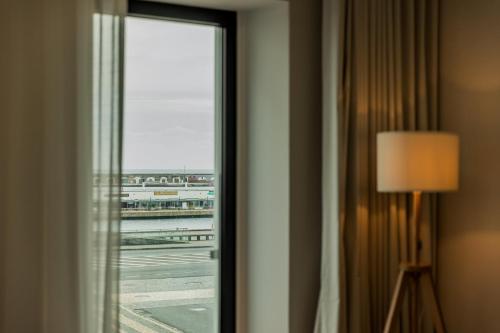 a window in a hotel room looking out at an airport at Casa Rua da Fonte - Modern & Relax (Bay View) in Ponta Delgada