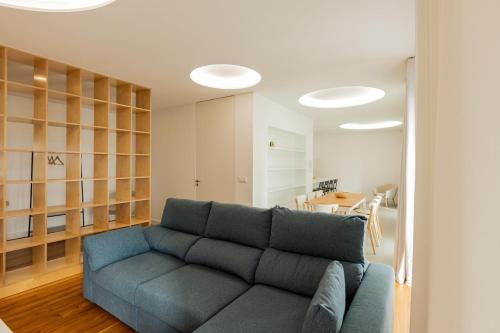 a living room with a blue couch and a table at Casa Rua da Fonte - Modern & Relax (Bay View) in Ponta Delgada
