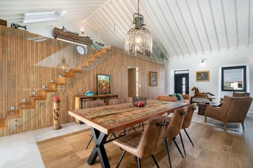 a dining room with a wooden table and chairs at São Brás Luxury Home - Jacuzzi & Garden in Sao Bras