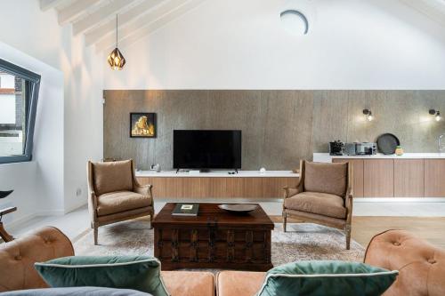 a living room with a couch and chairs and a tv at WelcomeBuddy - São Brás Collection Jacuzzi&Garden in Porto Formoso