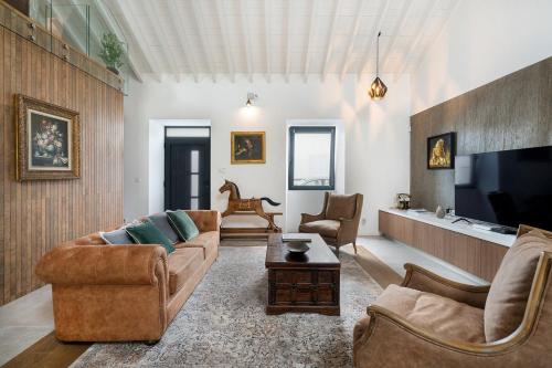 a living room with two couches and a flat screen tv at São Brás Luxury Home - Jacuzzi & Garden in Sao Bras