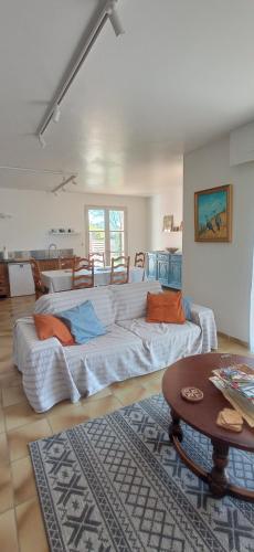 - un grand canapé blanc dans une chambre avec une table dans l'établissement UNE CHOUETTE MAISON, à Beaucaire