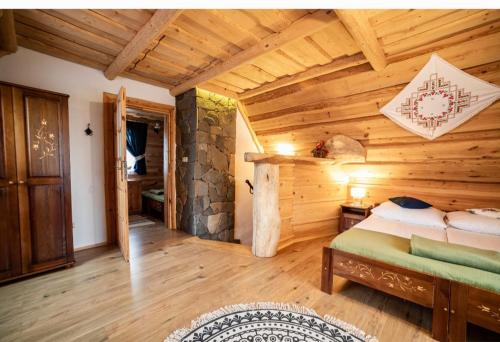 a bedroom with a bed in a wooden room at Domki u Bobaków in Ząb