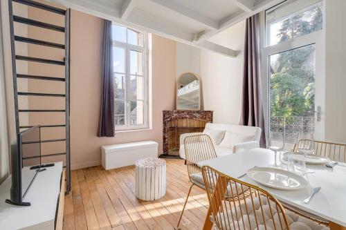 a living room with a white table and chairs at Le Natural Fauriel avec terrasse in Saint-Étienne