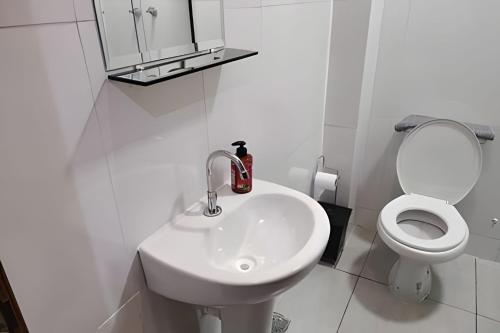 ein weißes Bad mit einem Waschbecken und einem WC in der Unterkunft Xavi Studio - Proximo ao Boulevard Shopping, Av Nacoes Unidas e Nuno de Assis. in Bauru