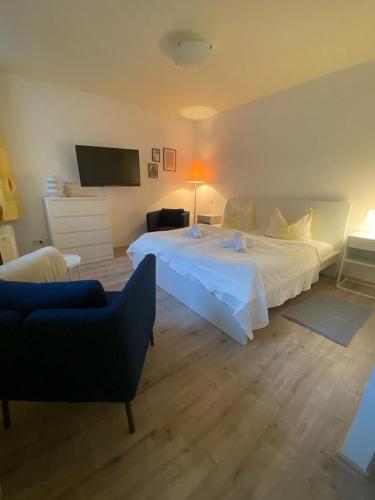 a bedroom with a large white bed and a couch at Apartments in der Rostocker Innenstadt in Rostock
