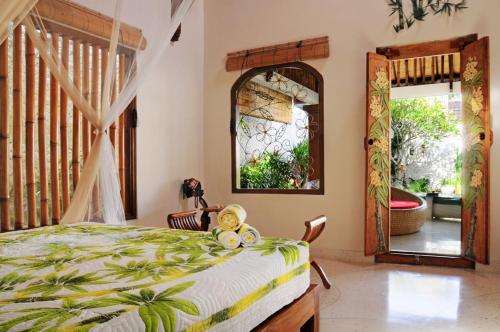 a bedroom with a bed and a large mirror at Villa Domus De Janas in Seminyak